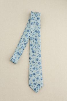 It's a perfect color match! Our Satin Floral Print Tie will provide that finishing touch to your cohesive wedding look! Classic in design our tie lends a stylish and comfortable fit. FEATURES: Semi-shine charmeuse satin material, unlined Classic narrow-width design Our Revelry custom floral prints are designed as tonal watercolor patterns and come in three sizes; a small ditsy print "posey", a modern medium print "bouquet", and a larger floral print with less background space "garden". Each prin Elegant Blue Cotton Ties, Elegant Blue Cotton Suit And Tie Accessories, Elegant Floral Print Ties For Spring, Elegant Summer Floral Print Ties, Elegant Floral Print Summer Ties, Spring Floral Print Fitted Suit And Tie Accessories, Spring Black Tie Event Ties, Spring Suit And Tie Accessories For Black Tie Events, Spring Wedding Floral Print Suit And Tie Accessories