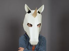 a woman wearing a paper mask with an animal's head on it