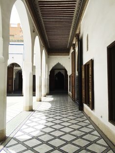 an empty hallway with tiled floors and wooden doors in arabic style architecture at the alhambra palace, marraket, morocco