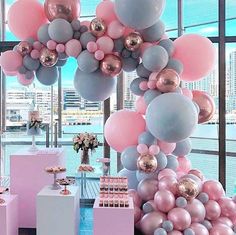 a room filled with lots of pink and grey balloons