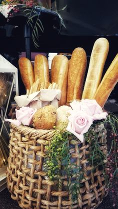 a basket filled with loaves of bread and flowers