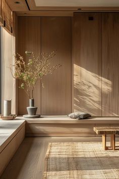 a wooden bench sitting in front of a window next to a vase filled with flowers