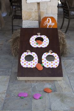 a cornhole game with paper pumpkins on it