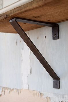 a wooden shelf with metal brackets on it