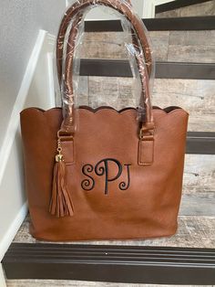 "Brown Scalloped Tasseled Tote with Monogram This listing is for one Brown monogrammed scalloped tote. This tote make the perfect birthday, Mother's Day, wedding party, and holiday gift. This pretty tote with a scalloped top will add a colorful touch to your outfit. Faux Textured Leather No Closure Velvet Like Interior Tassel Charm Metal Feet on Bottom Double Handles with 8.5\" Drop 14\" Wide (Bottom) x 11.5\" Tall x 5.25\" Deep ORDERING INFORMATION Please put the following information in the \" Customizable Brown Rectangular Bag, Customizable Bags For Gifts, Customizable Bags For Gift, Elegant Personalized Bags For Everyday Use, Elegant Personalized Bags As Gifts, Elegant Personalized Bags For Gifts, Personalized Brown Rectangular Bag, Personalized Brown Bags For Everyday Use, Personalized Rectangular Brown Bag