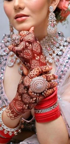 a woman with henna on her hands and bracelets around her wrist is posing for the camera