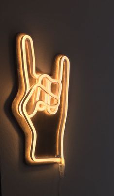 a neon sign that has a hand holding a peace sign on it's side