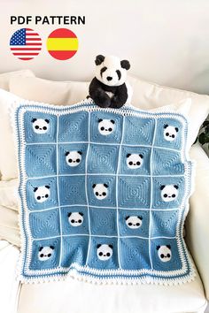 a stuffed panda bear sitting on top of a pillow made from crocheted squares