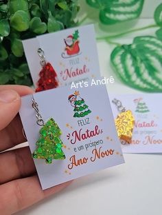 two christmas tree earrings are being held in front of a card with the words art's andde on it