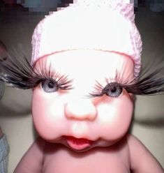 a close up of a baby with fake eyelashes