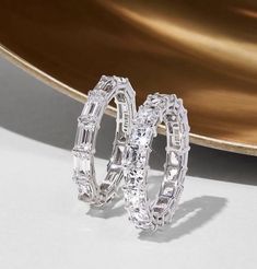 two diamond hoop earrings sitting on top of a table