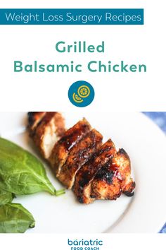 grilled balsamic chicken on a white plate with spinach leaves next to it