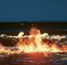 there is a fire in the ocean with water splashing around it