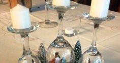 three wine glasses with snowmen and christmas decorations in them sitting on a table next to candles