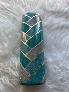 a blue and silver vase sitting on top of a white furnishing covered floor