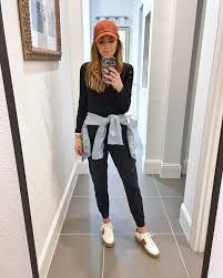 a woman is taking a selfie in the mirror while wearing sneakers and a turban