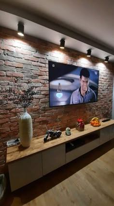 a large flat screen tv mounted to the side of a wall next to a wooden table