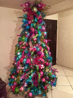 a brightly colored christmas tree with ribbons and bows