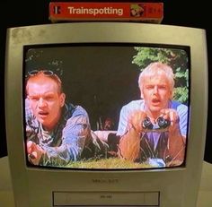 an old tv with two men on it's screen and one is holding a camera