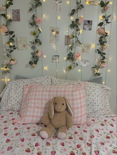 a stuffed animal sitting on top of a bed in a room with flowers and lights