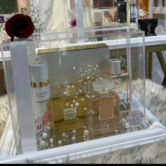 an assortment of perfumes displayed in clear acrylic cases on furnishing