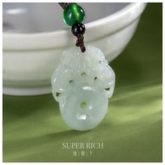 This exquisite jadeite pendant features a beautifully hand-carved "Qilin Ping An Kou" (麒麟平安扣) design, symbolizing peace, protection, and good fortune. The Qilin, a mythical creature in Chinese culture, is believed to bring safety and prosperity to its wearer. Crafted from high-quality jadeite, this pendant embodies the virtues of wisdom, balance, and harmony. Ideal for those seeking a meaningful and elegant piece of jewelry that not only enhances their style but also offers spiritual benefits. P Jade Gemstone Amulet Necklace, Carved Jade Jewelry For Good Luck, Chinese Jade Necklace, Green Jade Amulet Necklace, Carved Jade Pendant Necklace, Carved Jade Pendant Jewelry, Jade Necklace Pendant Chinese, Jade Dragon Pendant, Good Fortune