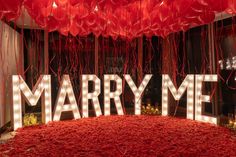 the word marry me is surrounded by balloons and streamers