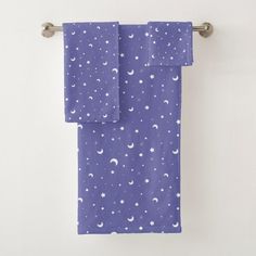 two towels hanging on a towel rack in front of a white wall with stars and crescents