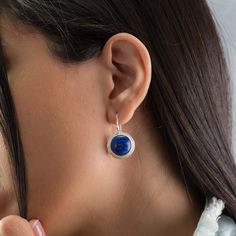 Make a bold and stylish statement with these stunning silver round dangle earrings! Each earring is intricately inlaid with a vibrant lapis stone, adding a pop of color and elegance to any outfit. These eye-catching earrings are perfect for adding a touch of sophistication to your look and are sure to turn heads wherever you go. Elevate your jewelry collection with these unique and beautifully crafted statement earrings. In addition there is a beautiful heart shape in the back of the earrings th Modern Round Earrings With Lever Back, Modern Round Pendant Earrings As Gift, Sterling Silver Hypoallergenic Round Pendant Earrings, Hypoallergenic Sterling Silver Round Pendant Earrings, Hypoallergenic Sterling Silver Pendant Earrings, Minimalist Sterling Silver Earrings With Round Stone, Sterling Silver Round Earrings With Lever Back, Lapis Stone, Round Dangle Earrings