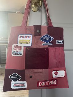 a bag hanging on a door with stickers all over it's front pocket