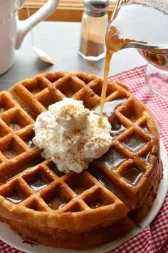 a waffle with syrup being poured onto it