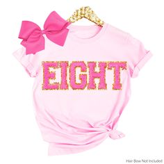 a t - shirt with the word eightt on it and a pink bow at the front