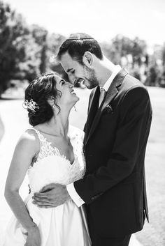 a bride and groom share a tender moment in black and white, as they stand close to each other