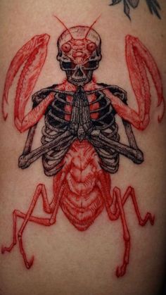 a skeleton and lobster tattoo on the back of a woman's shoulder with red ink