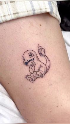 a small tattoo on the thigh of a woman's leg with a cartoon character