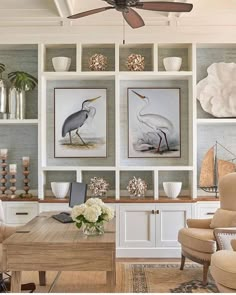 a living room filled with furniture and paintings on the wall above it's fireplace