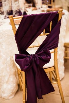 the back of a chair with purple sashes on it