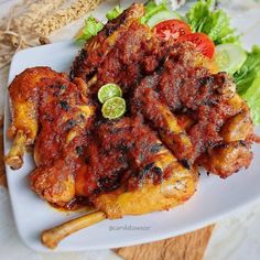 chicken wings with tomatoes and lettuce on a white plate