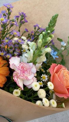 a bouquet of flowers is wrapped in brown paper