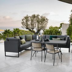 an outdoor patio with furniture and trees in the background