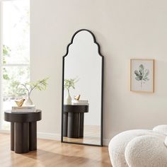 a living room with a mirror, stool and table in it's centerpiece