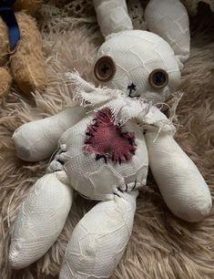 a white teddy bear sitting on top of a pile of fur