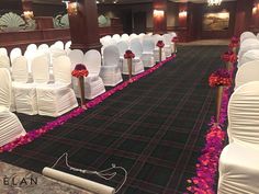 a banquet hall with rows of white chairs and pink flowers on the carpeted floor