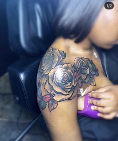 a woman with a rose tattoo on her chest holding a purple object in her hand