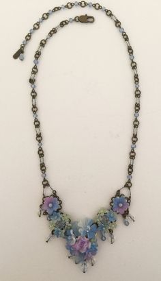 Petite delicate pendant style necklace with pretty mixed hues of soft purple and blue almost a periwinkle. The flowers are hand painted and the entire necklace is beaded with thread and wire. Including the necklace itself. This is a nice style for a more petite body or someone who wants a necklace that is more delicate. This necklace would look great with a pretty summer dress or can be worn casually with even a pair of jeans. Earrings on the model are also available. This is a quality piece of Blue Flower-shaped Beaded Necklace Gift, Blue Flower-shaped Jewelry With Beaded Chain, Jeans Earrings, Pretty Summer Dress, Elegant Flower-shaped Necklace With Colorful Beads, Blue Jasmine, Blue Flower-shaped Bohemian Necklace, Vintage Blue Hand-strung Beaded Necklaces, Pretty Summer Dresses