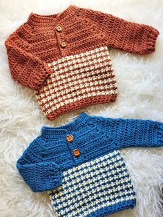 three knitted sweaters laying on top of a white rug