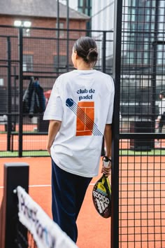 a woman standing on a tennis court holding a racket and ball in her hand