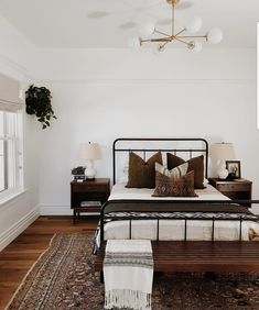 a bedroom with white walls and wooden floors