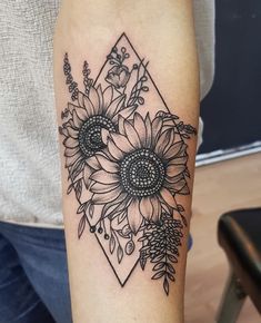 a sunflower tattoo on the arm with an arrow and flower arrangement in black ink