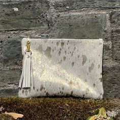 This Breccia clutch is a beautiful bag that is great for so many occasions, or for use everyday with style! Dimensions: Height: 18cm (7.08in) Width: 24cm (9.4in) Flat construction It is made from hair on cowhide with metallic gold splash on the front with soft, cream leather on the back or you can choose cowhide on both sides - please see the Material options below.  The Breccia has a cotton, stripped lining and has a handy credit card  pocket inside. It has a pretty YKK gold colour zip with a beautiful matching, detachable tassel. PLEASE NOTE; we cannot deliver to Germany. Delivery is via Royal Mail  first class for UK buyers and Standard International Delivery (3-7 business days) for elsewhere. Should you need your purchase sooner please contact me before ordering. Please note wrist stra Gold Splash, Cowhide Clutch, Gold Clutch Bag, Gold Clutch, Gold Bag, Orange Leather, Gold Colour, Colored Leather, Gold Leather